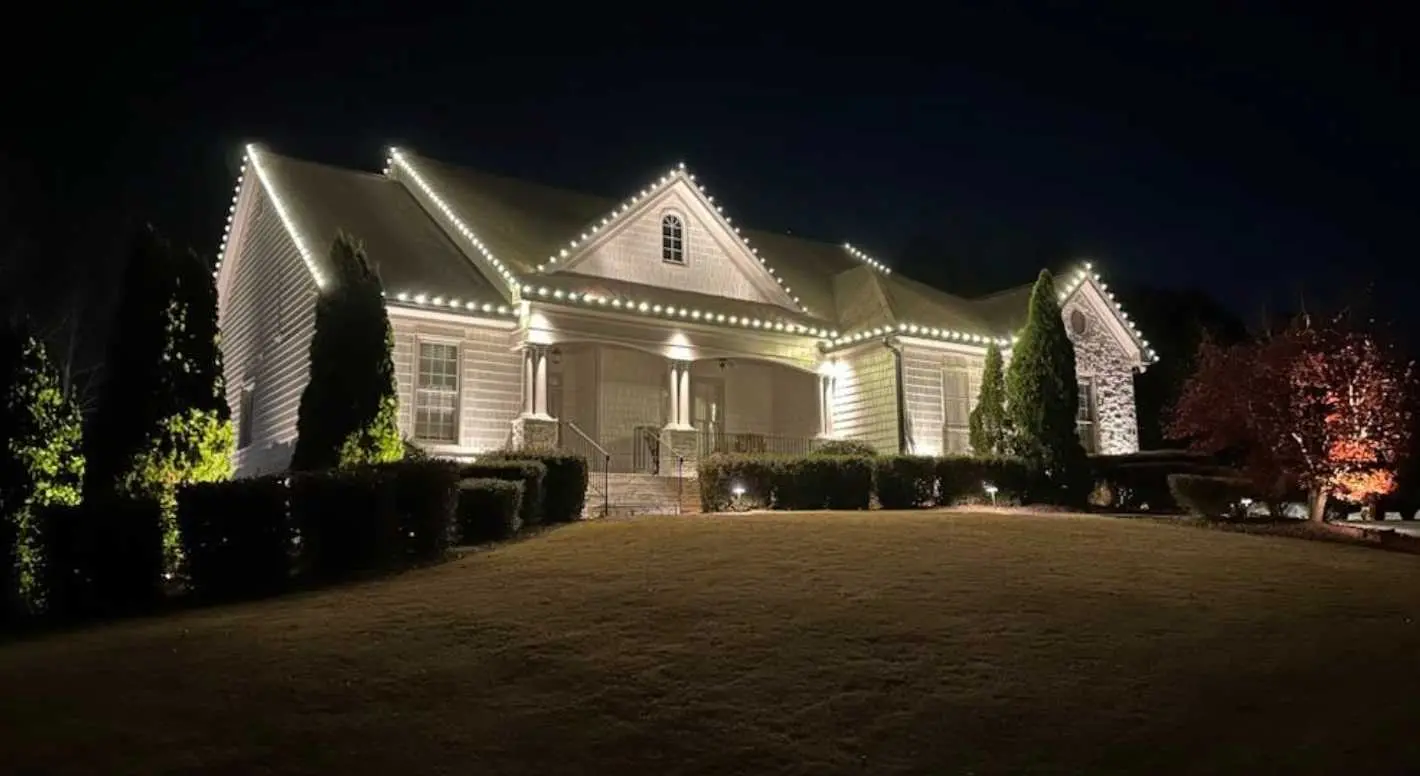 Elegant warm white holiday lights outlining a large home and architectural details in Cumming, GA.