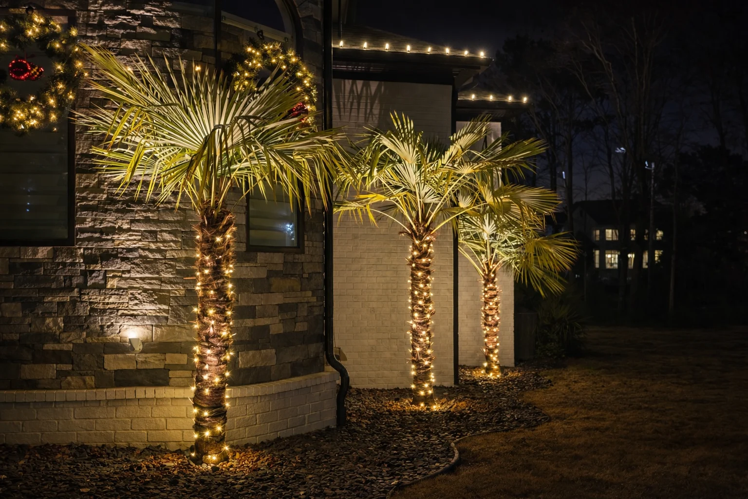 Warm white decorative lights wrapped around landscape trees for an outdoor holiday lighting display in Cumming, Georgia.