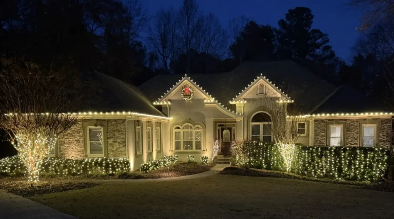 Warm white roofline and landscape Christmas lights illuminating a residence in Cumming, Georgia.